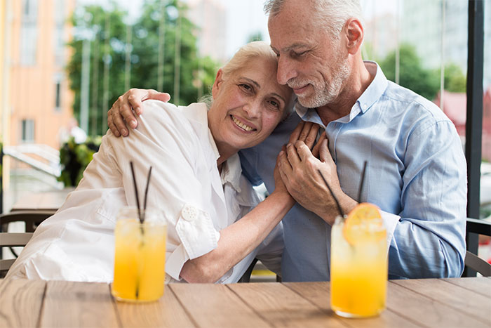 Elderly couple enjoying a date at a restaurant with orange drinks, servers sharing the worst dates they witnessed at work