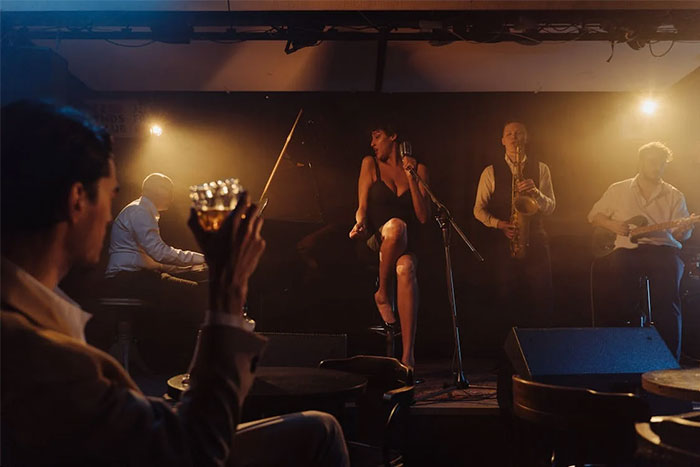 Customer at a restaurant raising a glass while a live band performs, showing the atmosphere where servers witnessed worst dates.