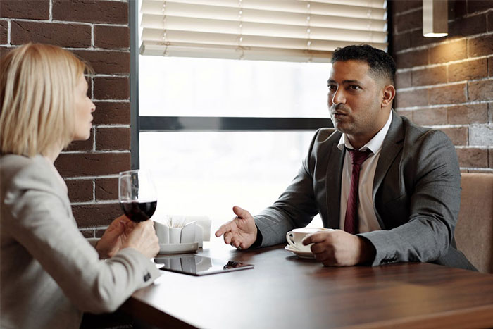 Man and woman on a tense date at a restaurant, illustrating servers witnessing the worst dates at work.