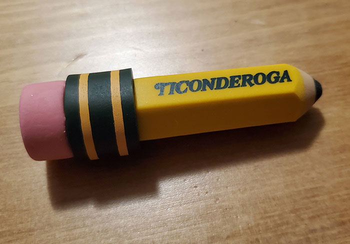 Yellow Ticonderoga pencil with pink eraser on wooden surface, symbolizing mansplain concept and women's eye rolling reaction.