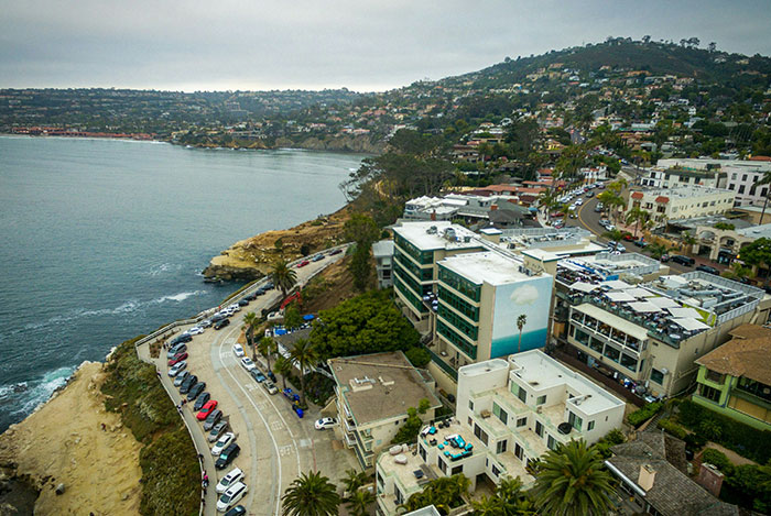 Coastal view of a scenic town with winding roads and buildings, illustrating mansplain moments causing eye rolls.
