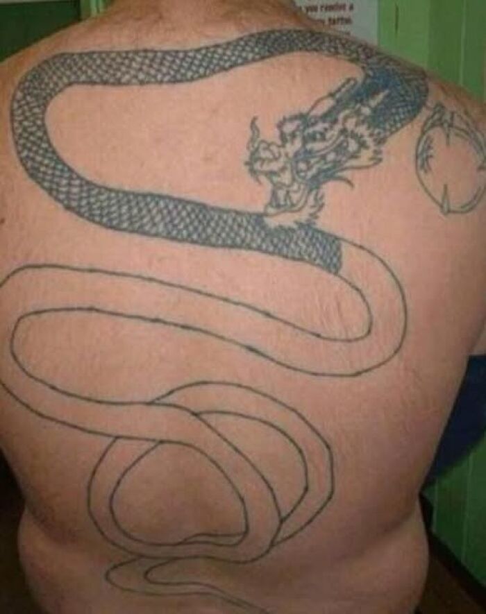 Large back tattoo of a dragon with incomplete and poorly detailed design featured in bad tattoos collection.