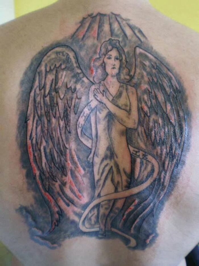 Tattoo of an angel with wings on a back, showcasing one of the worst abysmally bad tattoos from dedicated FB pages.