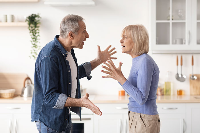 Middle-aged couple arguing intensely in kitchen, depicting emotional conflict about dad, illegitimate son, and DNA results. Middle-aged couple arguing intensely in kitchen, depicting emotional conflict about dad, illegitimate son, and DNA results.