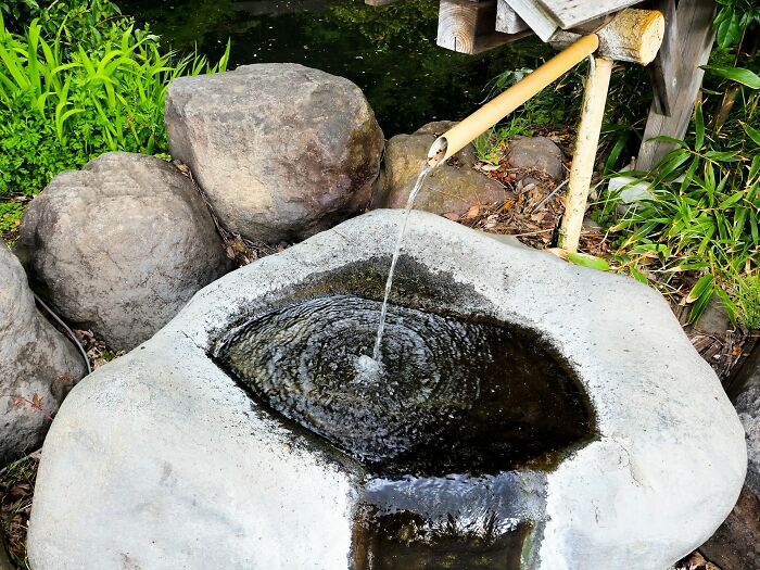 Stone water basin with water flowing from bamboo pipe, symbolizing neglect in punishing kids left alone for days without food.