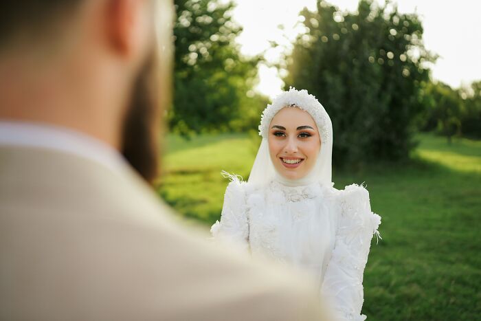 Bride in a white dress and headpiece smiling at groom outdoors, illustrating common religious myths about Jesus and the Bible.