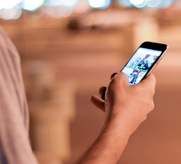 Person holding smartphone browsing social media, highlighting predators targeting children's social media comments.