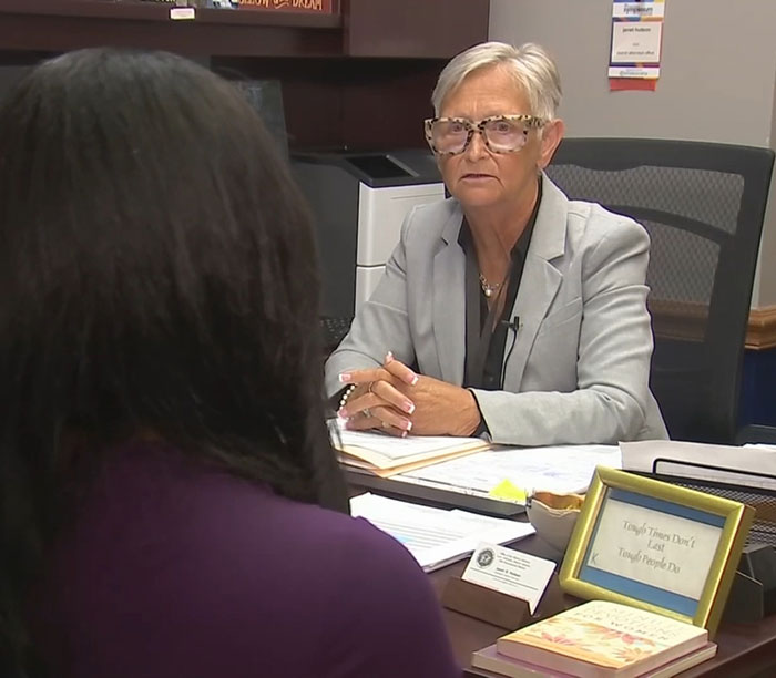 Woman in a gray blazer discussing felony charges involving stepdad and mom after 11-year-old gives birth at home without medical help.