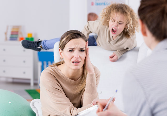 Stressed woman dealing with friend’s rowdy kids, deciding to host only childfree events in the future. - 1