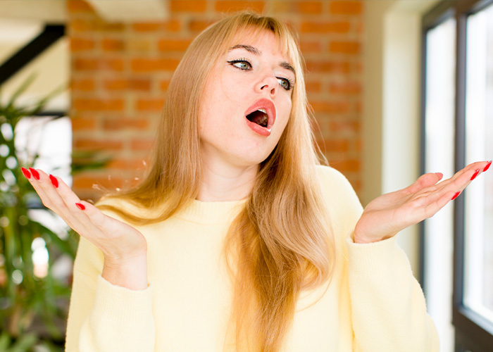 Woman in yellow sweater expressing surprise and frustration, illustrating a moment with a deaf man who is very quiet.