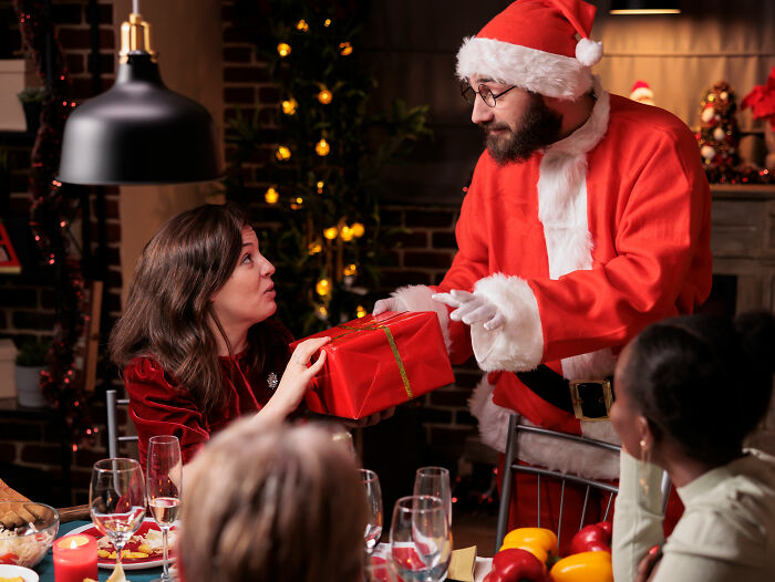 Man dressed as Santa rejecting woman offering a gift during a festive gathering, illustrating stories of savagely rejected love.
