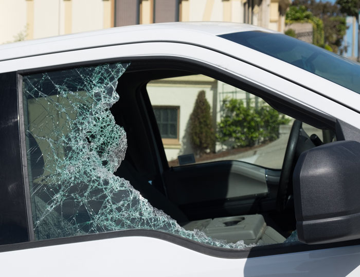 Broken white truck window with shattered glass, highlighting security camera footage of wild home cam scenes.