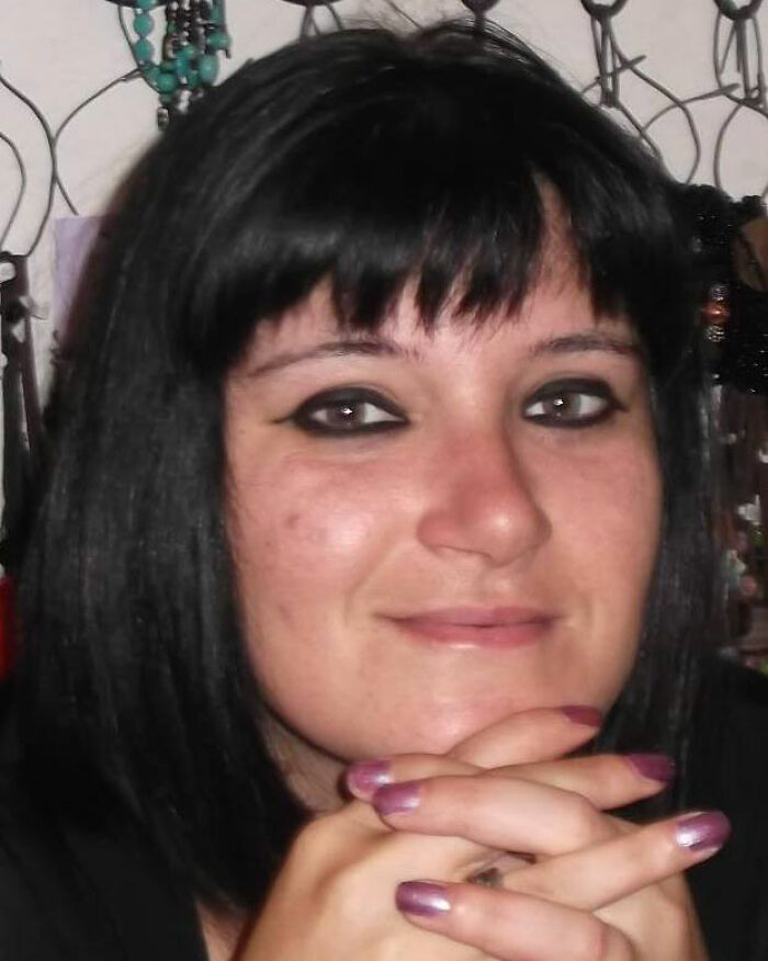 Woman with dark hair and black eyeliner, resting chin on clasped hands, related to toxic broccoli sandwich investigation.