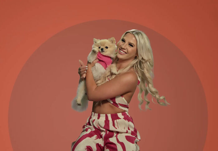 Woman smiling and holding small dog, representing story about woman accidentally leaving tampon inside for a month