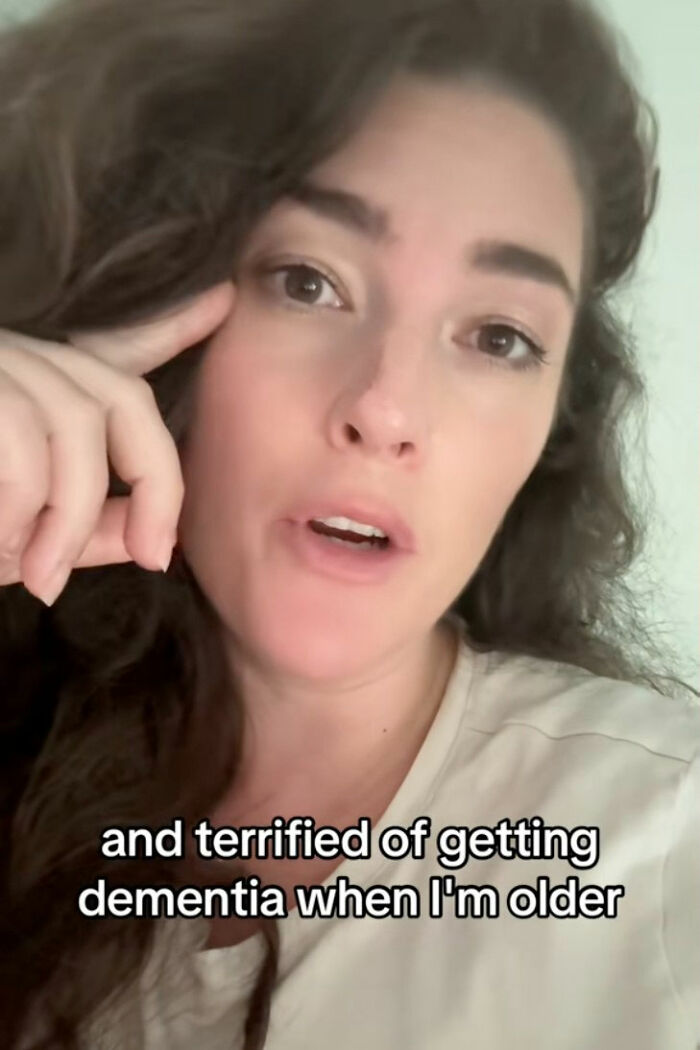 Woman with long hair wearing a white shirt, sharing a tiny habit to help prevent heart attack and dementia risk.