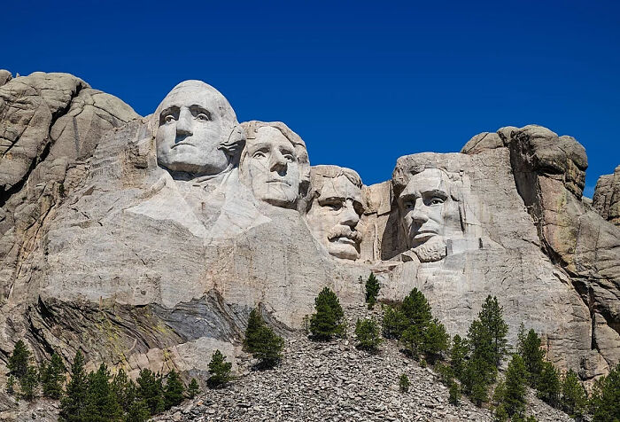 Mount Rushmore showing the carved faces of US presidents under a clear blue sky, unrelated to Boops Boops fish facts.