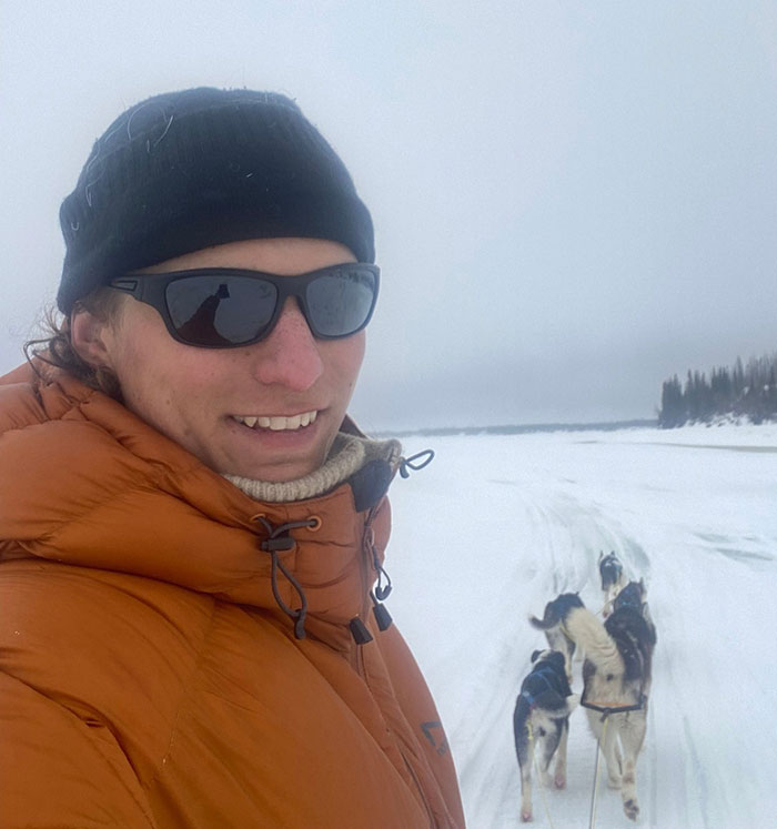 29-year-old man in winter gear with dogs on snowy trail, highlighting risks of lone hiking adventures.