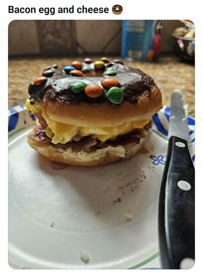 Chocolate donut sandwich with bacon, egg, and cheese on a paper plate with a knife, unhealthy food affecting physical and mental health.