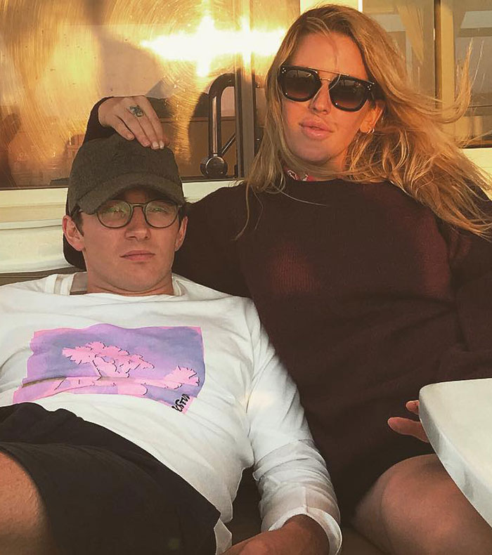Ellie Goulding wearing sunglasses and posing with a man, sparking romance rumors and racy selfie reactions from fans.