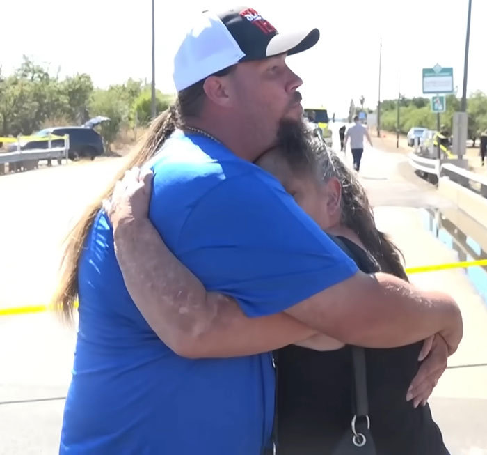 Two people embracing near a cordoned-off area where bodies of missing mom and baby were found. Two people embracing near a cordoned-off area where bodies of missing mom and baby were found.