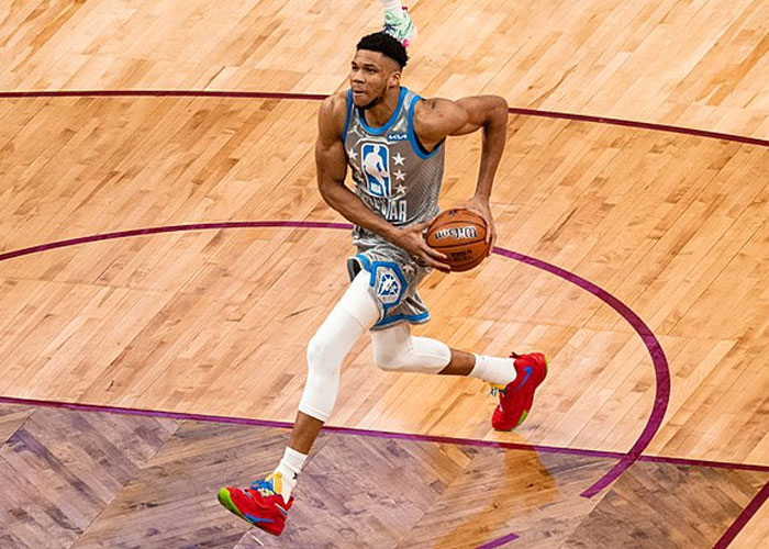 Basketball player in action on the court wearing a blue and gray uniform, emphasizing drive over the speed limit concept.