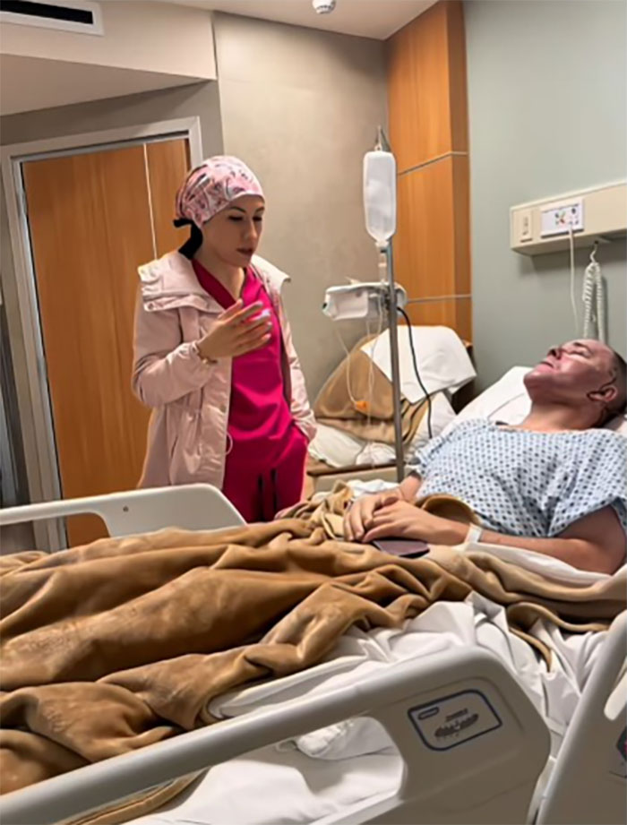 Man recovering from facelift in hospital bed as nurse in pink scrubs monitors him in medical room in Mexico. Man recovering from facelift in hospital bed as nurse in pink scrubs monitors him in medical room in Mexico.