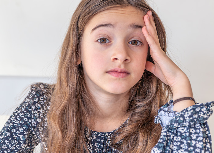 Young girl with long hair wearing a floral top, looking surprised, reflecting moments rich people realize normal life differences. - 10