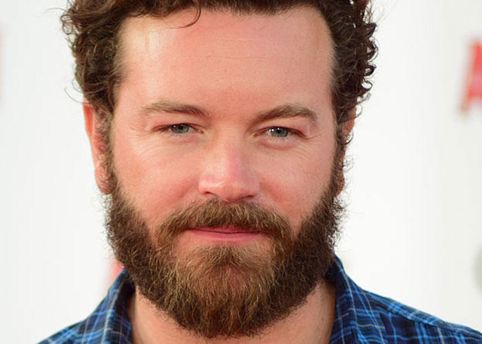 Bearded man in a blue plaid shirt smiling at a celebrity encounter event, capturing a total gentleman vibe.