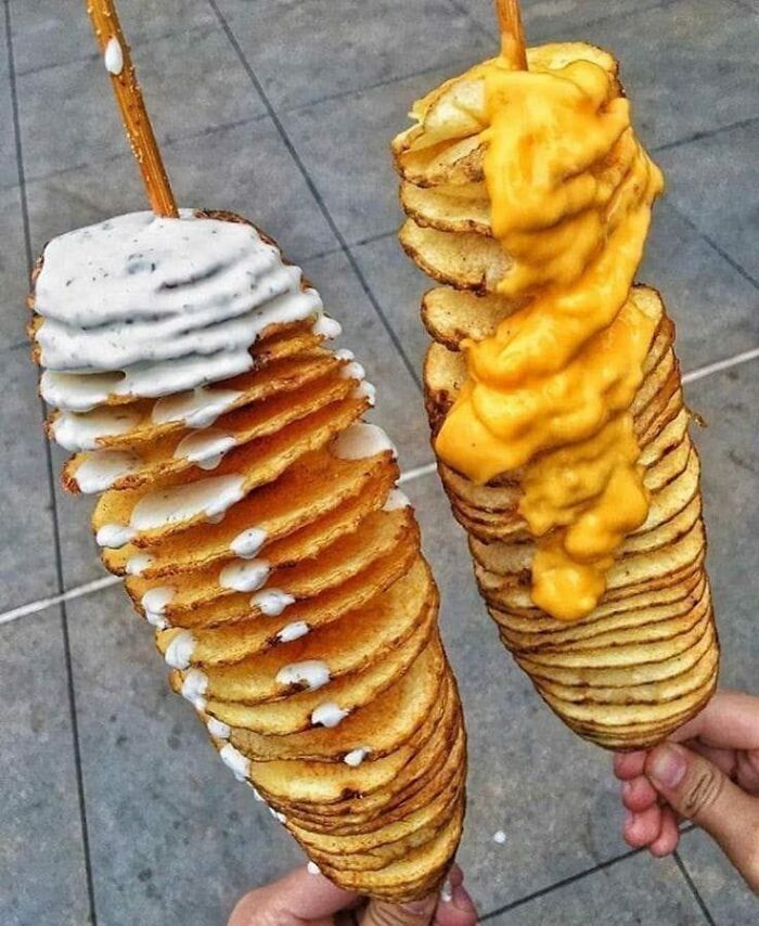 Twisted fried potato slices on sticks topped with cheese sauce and creamy dressing, unhealthy food to avoid for mental and physical health.