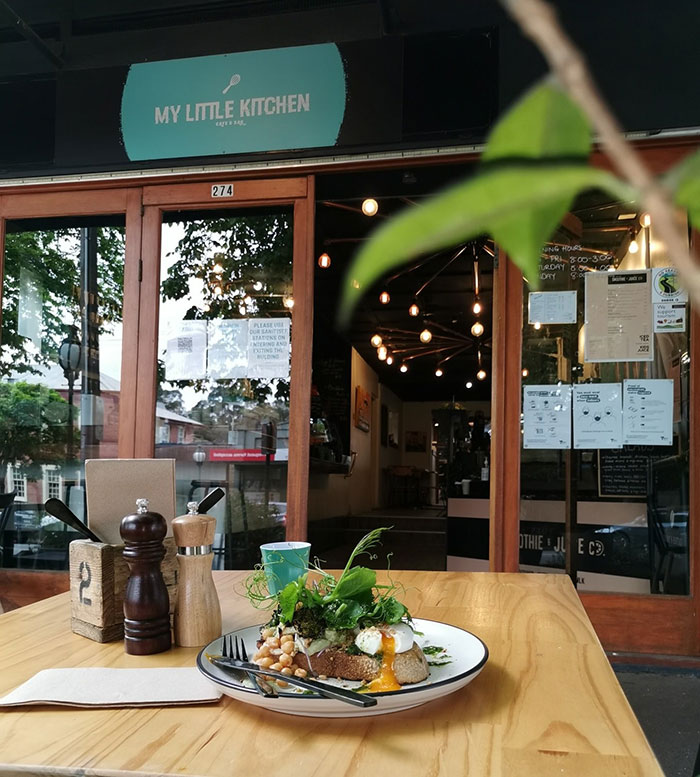 Plate of food on a caf&eacute; table with utensils outside My Little Kitchen, highlighting caf&eacute; owner and entitled customers issue.