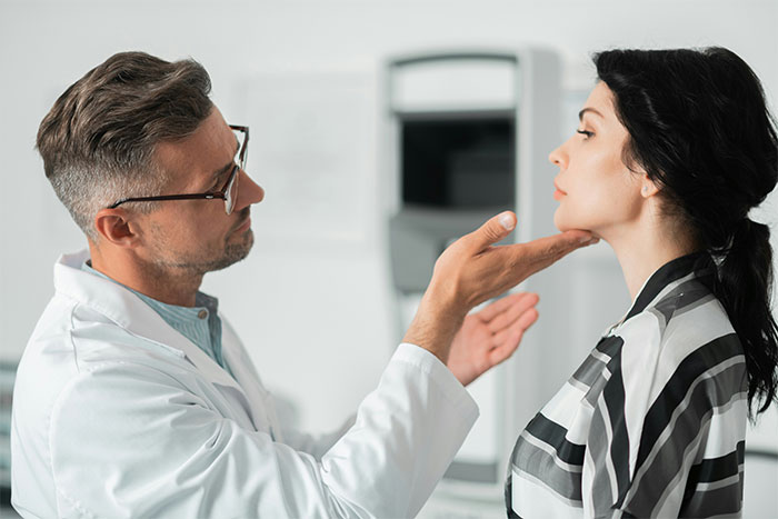 Doctor examining woman's face in a clinic, discussing facelift options with a focus on cosmetic procedure results. Doctor examining woman's face in a clinic, discussing facelift options with a focus on cosmetic procedure results.
