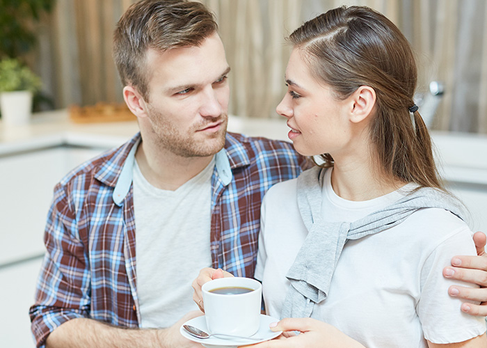 Young couple sharing a quiet moment with coffee, reflecting on lifestyle differences between rich people and most others. - 12