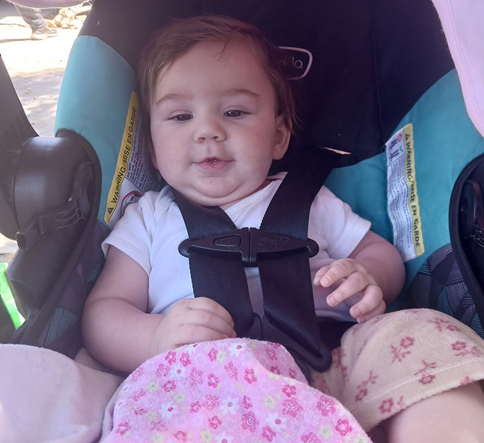 Baby girl secured in car seat wearing white shirt and pink floral blanket, related to missing mom and baby case. Baby girl secured in car seat wearing white shirt and pink floral blanket, related to missing mom and baby case.
