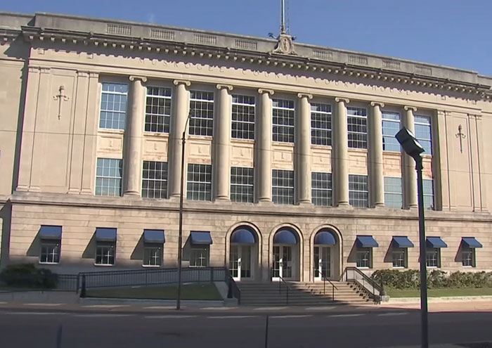 Courthouse exterior with columns and steps, related to stepdad and mom facing felony charges after home birth incident.