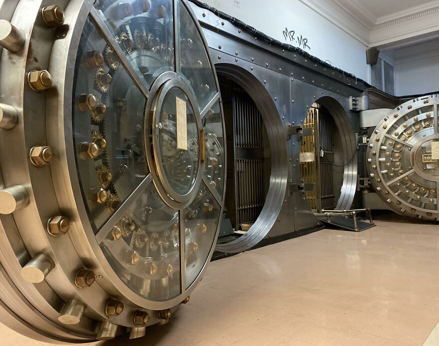 Large open bank vault doors with intricate gears and bolts, evoking real-life claustrophobia feelings. Large open bank vault doors with intricate gears and bolts, evoking real-life claustrophobia feelings.