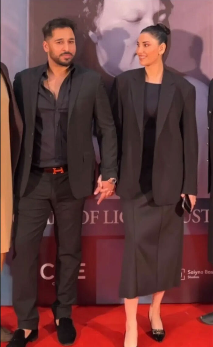 Man and supermodel wife holding hands on red carpet, related to intoxicated man's threat and wife defending his pain. Man and supermodel wife holding hands on red carpet, related to intoxicated man's threat and wife defending his pain.