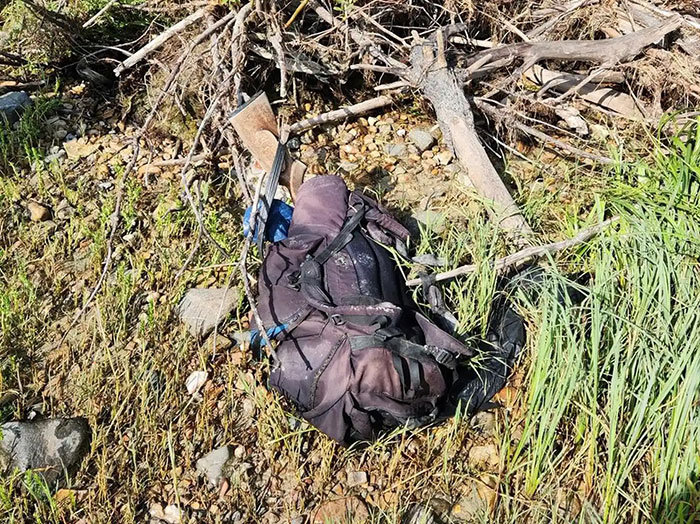 Backpack and hiking gear found in rocky area during police search for missing hiker on dream trip.