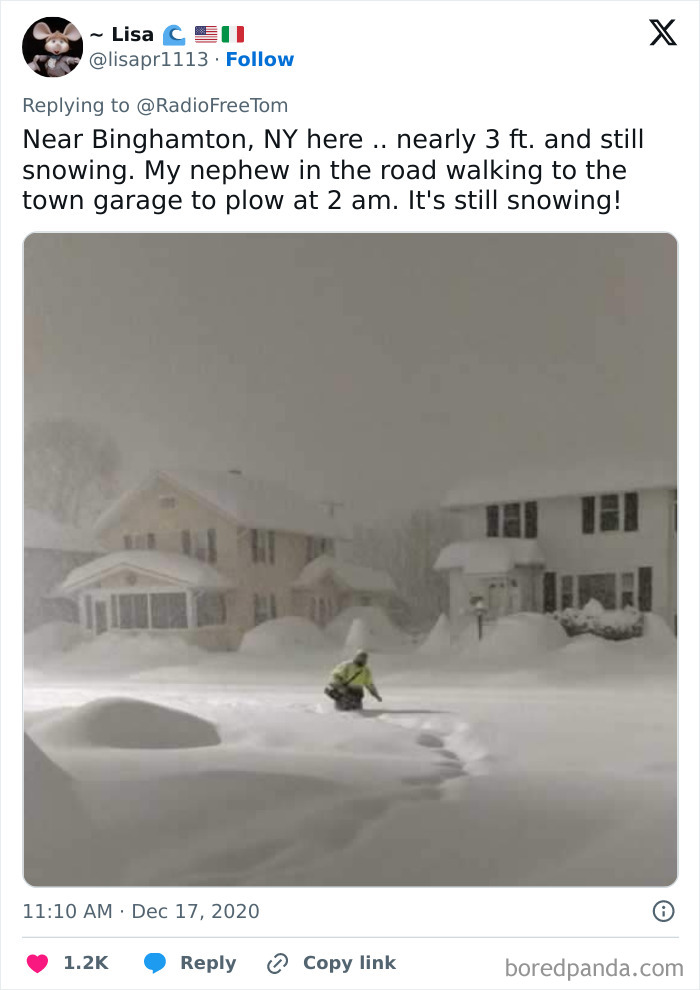 Person walking through deep snow near houses at night, showcasing Mother Nature doing things on its own terms in winter.