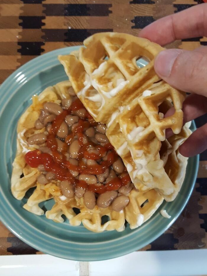 Waffle with beans and sauce on a plate, an example of food nobody should eat for physical and mental health.