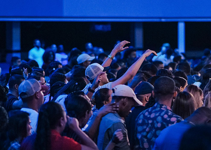 Crowded group of people with some raising hands, illustrating social interaction in jobs without a soul concept.