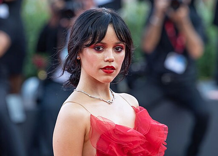 Young woman in a red dress posing at an event, captured during a celebrity encounter and wild experience moment.