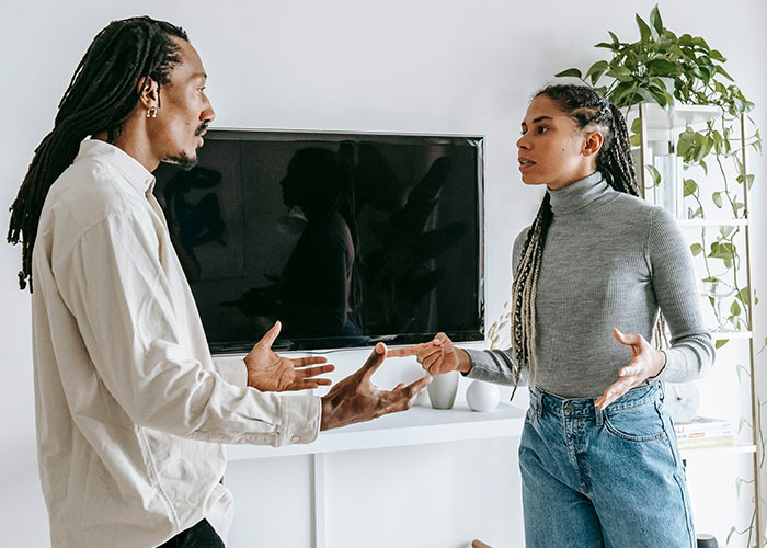 Two people in a casual setting having a serious conversation, illustrating wild and embarrassing drinking stories.