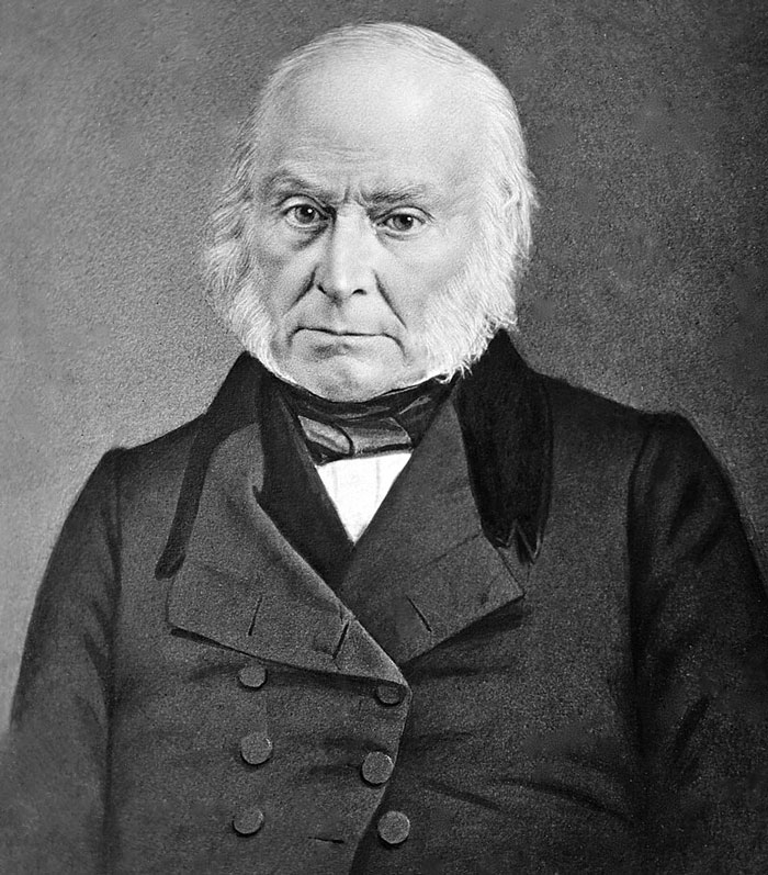 Black and white portrait of an elderly man with white hair and sideburns, posing formally in vintage attire and coat.