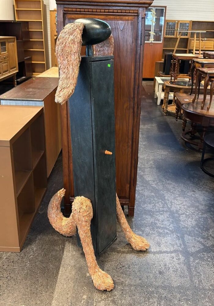 Odd DIY craft project resembling a dog with oversized ears and legs made from various materials in a furniture store.