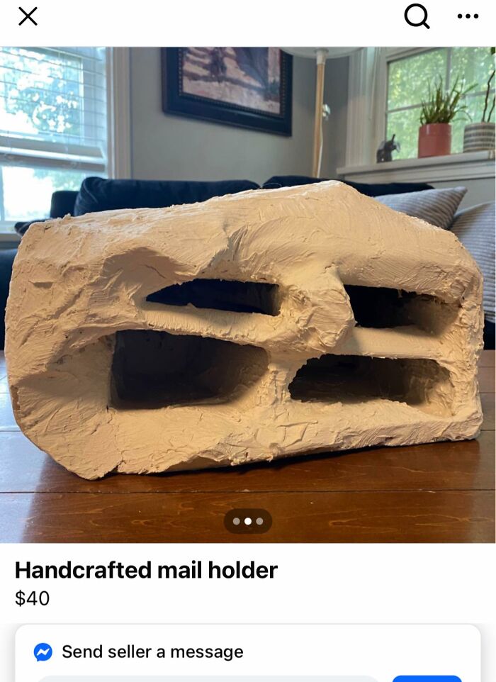 Roughly sculpted DIY handcrafted mail holder with uneven texture sitting on wooden table indoors.