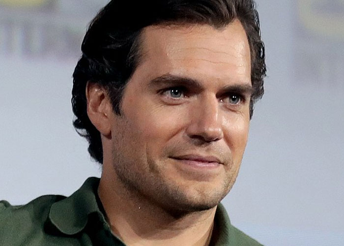 Close-up of a celebrity smiling during an event, embodying the charm of running into celebrities and wild experiences.