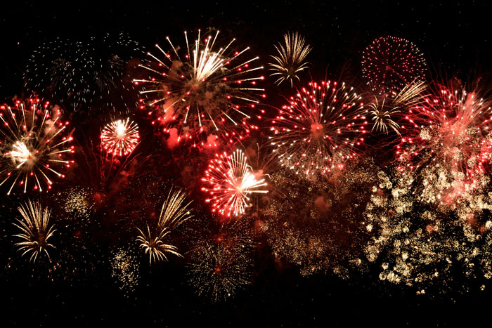 Colorful fireworks bursting against a dark sky, symbolizing extravagant and unhinged wedding spends celebration. - 36