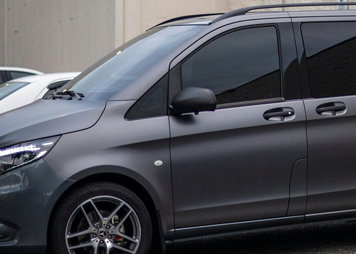 Matte gray car parked on street showcasing sleek design and tinted windows driving over the speed limit concept.