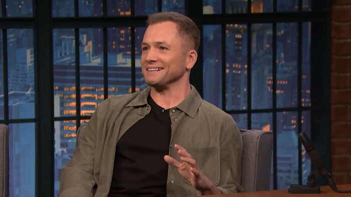 Actor smiling and gesturing during a late-night talk show, part of Hollywood celebrities who weren’t leading A-listers.
