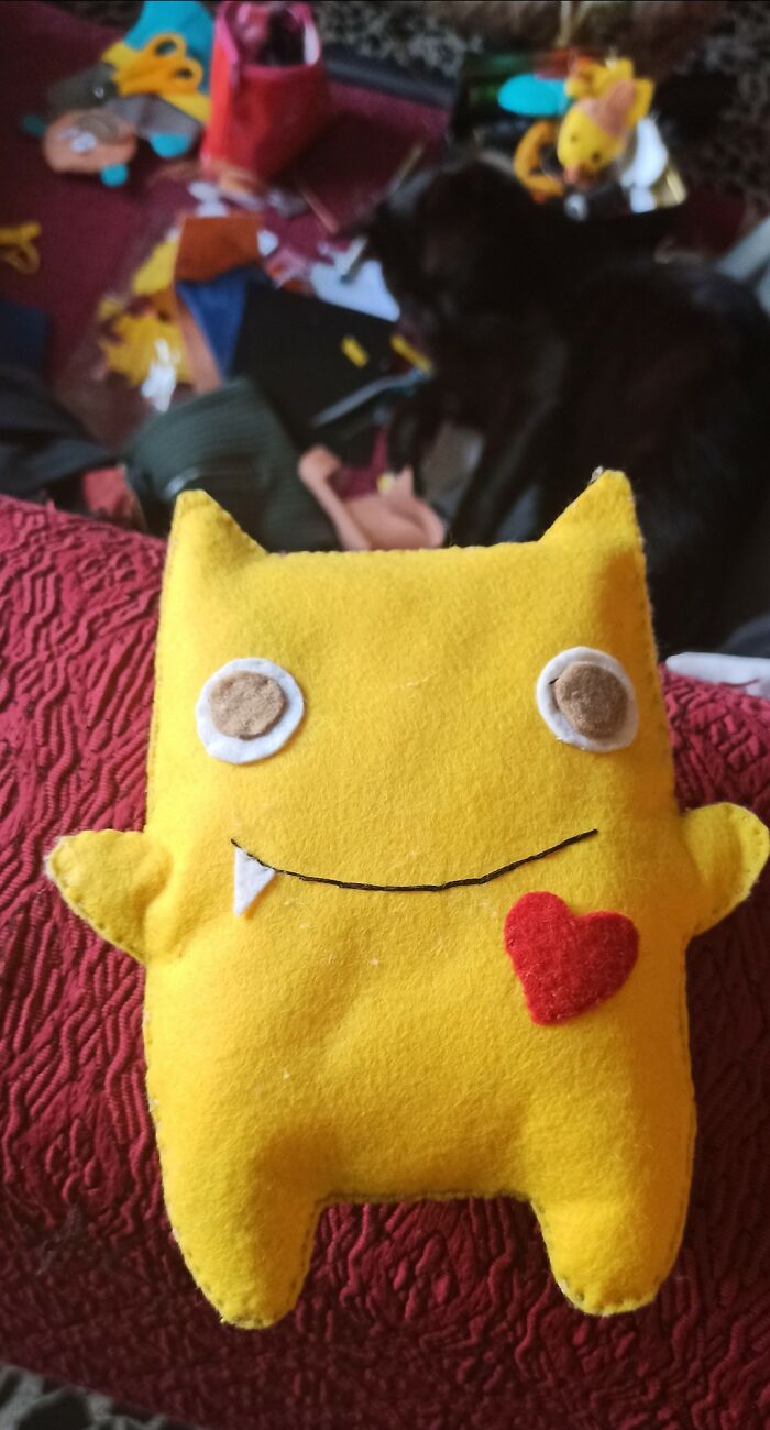 Yellow handmade felt plush with a red heart and mismatched eyes, an example of horrendous DIY craft shaming projects.